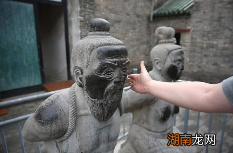 岳飞墓前的跪像曾有五个,现在为何只剩四个了?